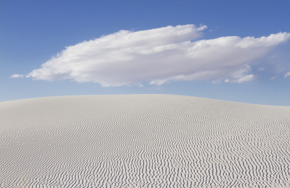 eine große flache Fläche mit einem bewölkten Himmel über dem White Sands National Monument im Hintergrund