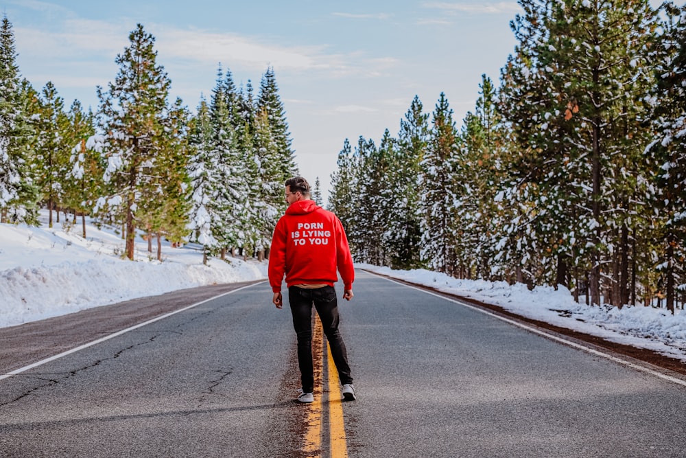 a person on a road with snow on the side