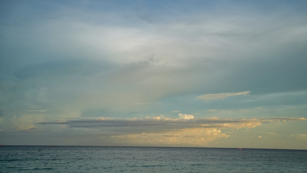 a body of water with clouds above it