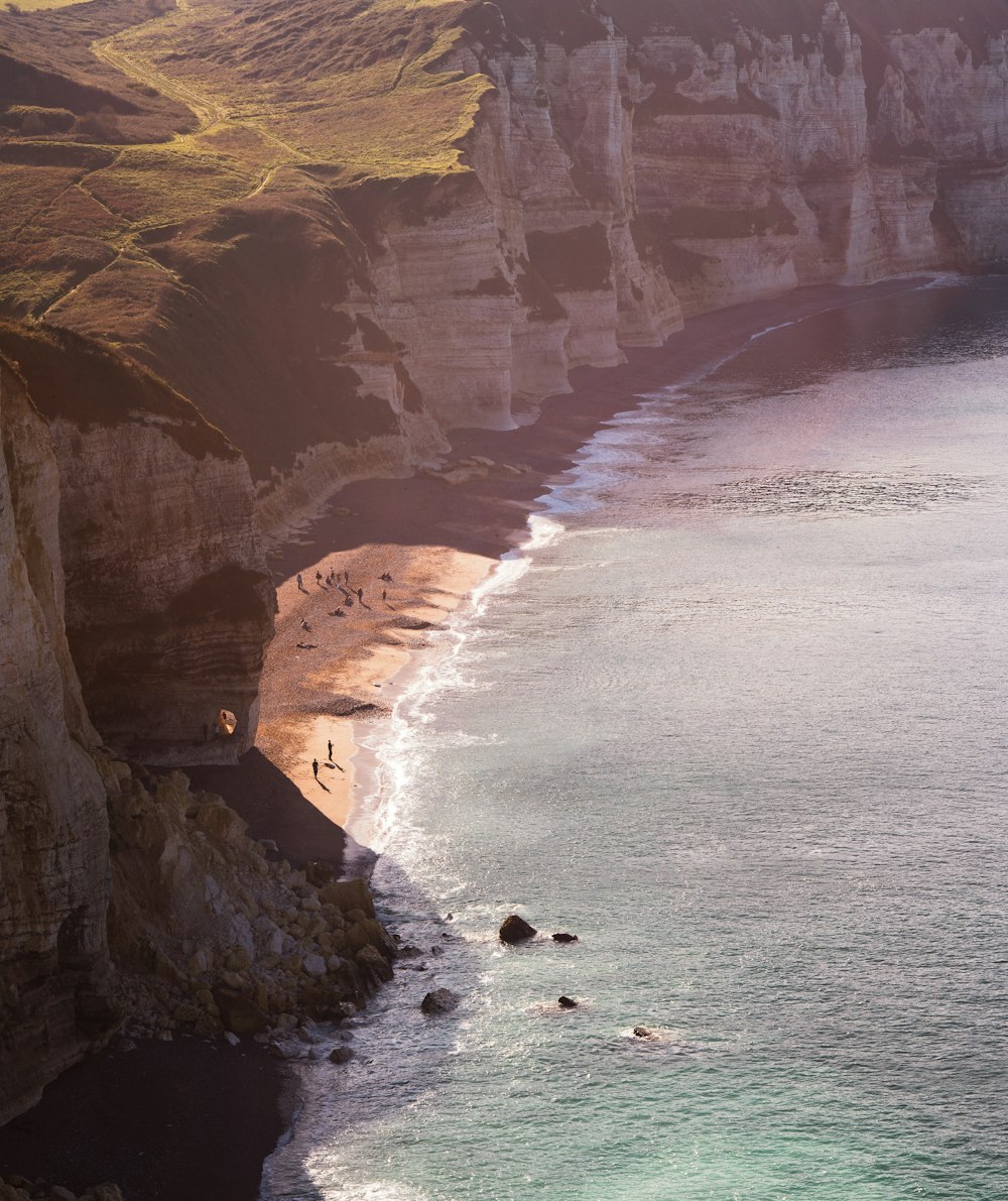 a beach with a cliff and water