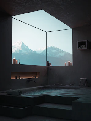 Serene bath area featuring natural stone, flowing water, and minimalist design.