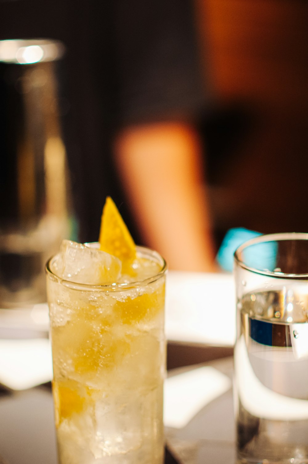 a glass of yellow liquid with a straw