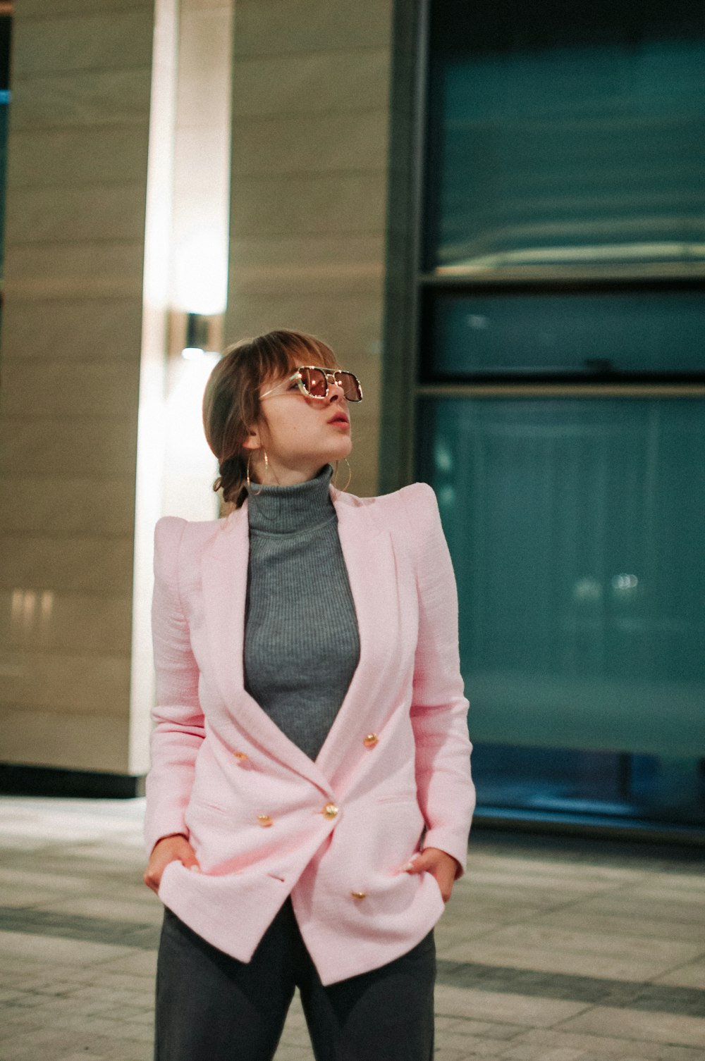 a woman wearing a pink jacket and sunglasses