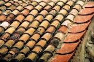 Wide shot of a warehouse filled with organized racks of terracotta and beton roof tiles.
