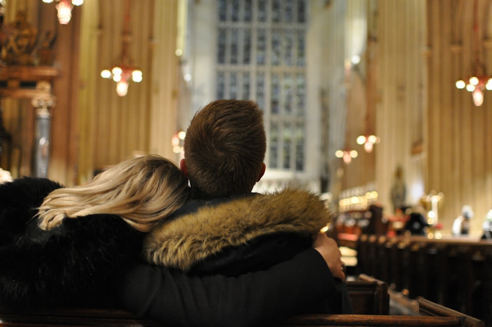 a man and woman sitting in a church