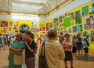 A vibrant art gallery with colorful paintings and visitors admiring the exhibits.