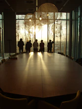 a group of people standing in a room with a large glass door