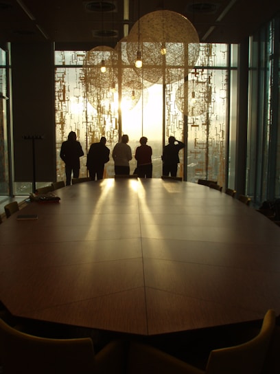 a group of people standing in a room with a large glass door