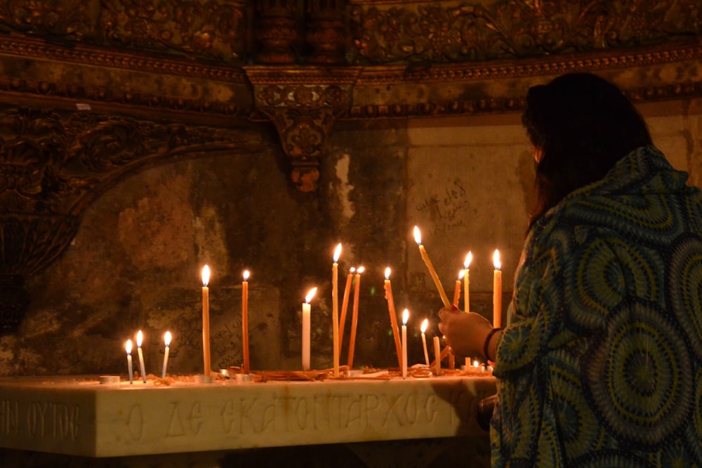 a person lighting candles in a church