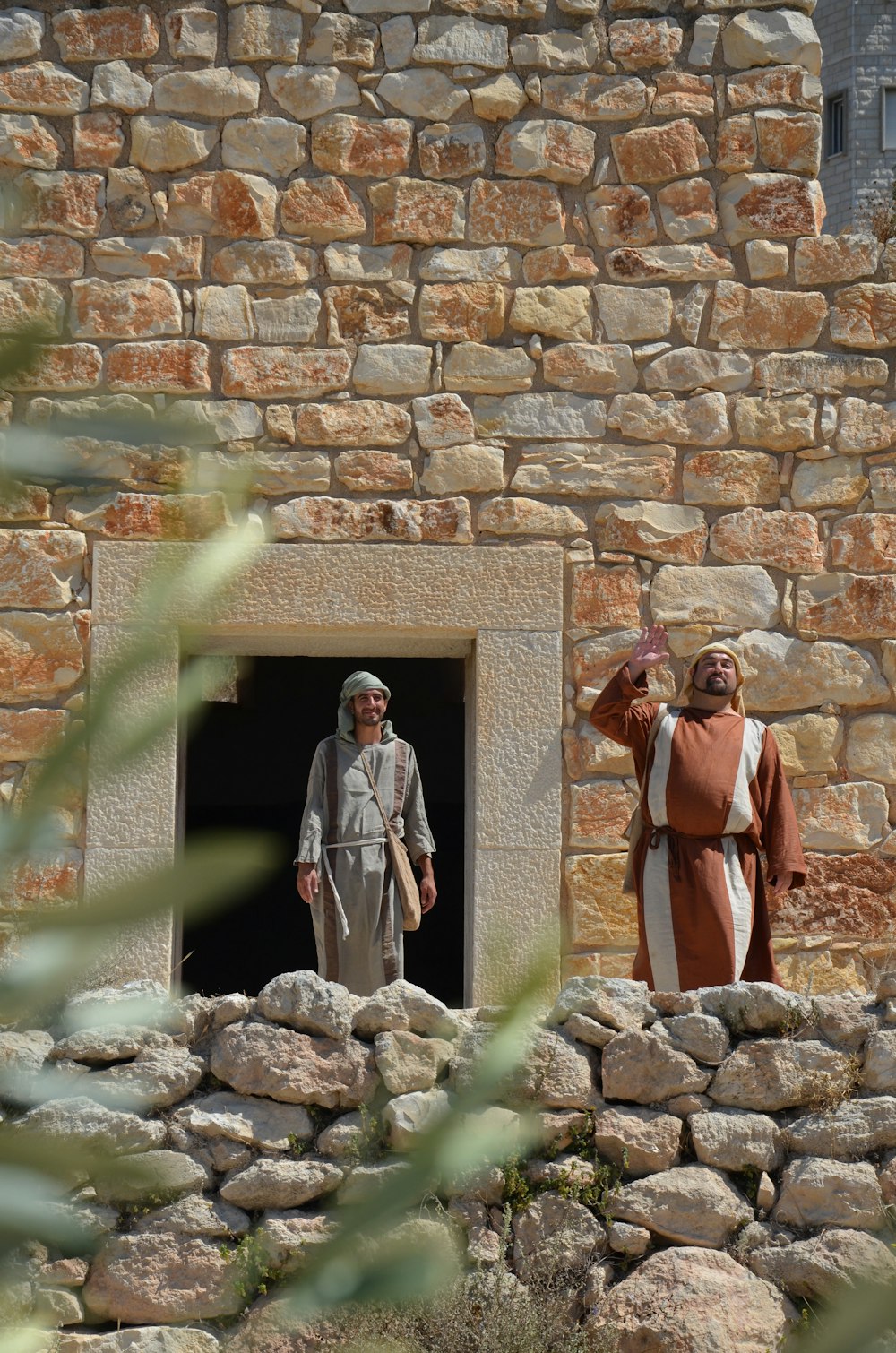 a couple of men standing in a doorway of a stone building