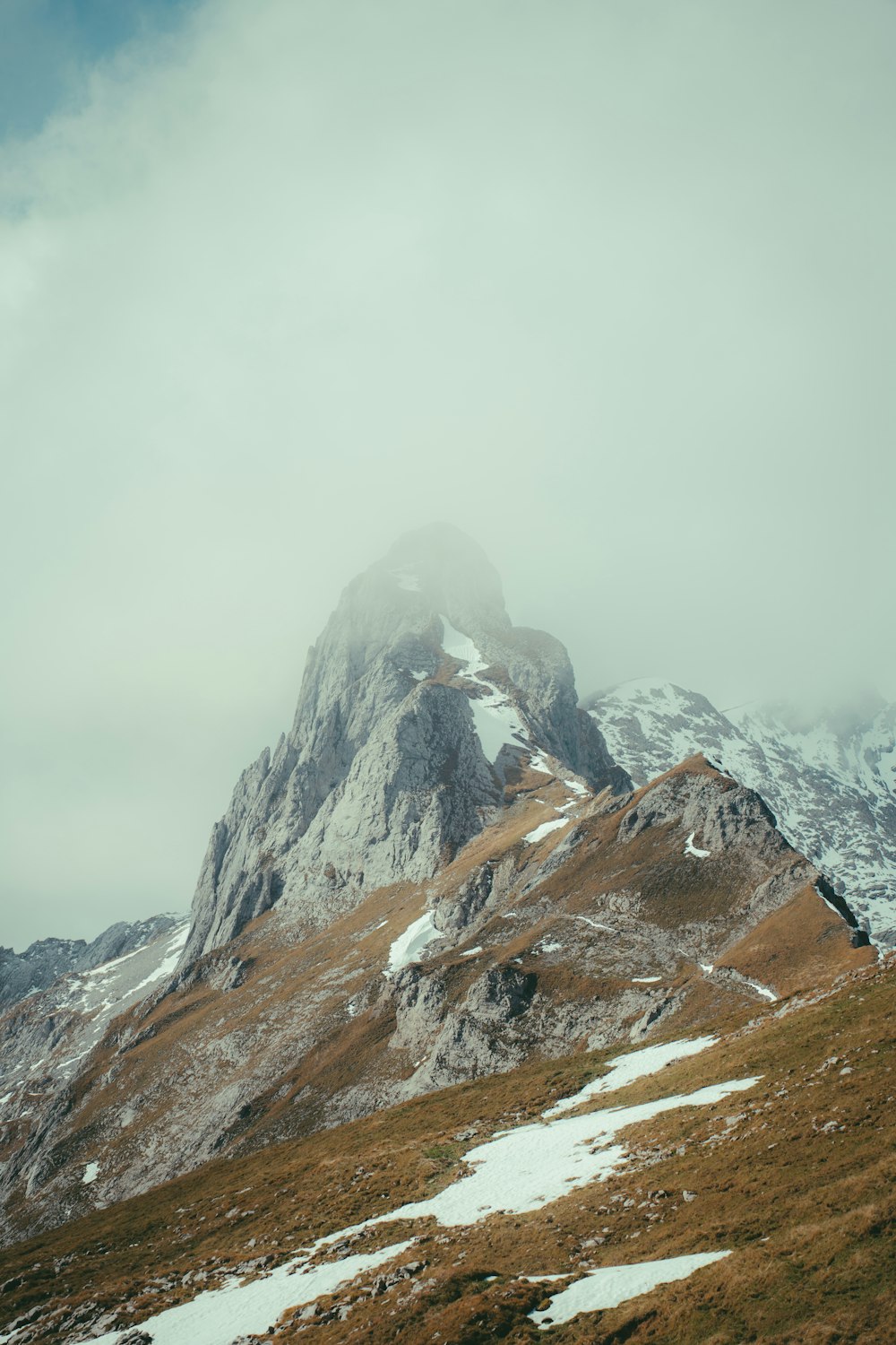 a snowy mountain with a foggy sky