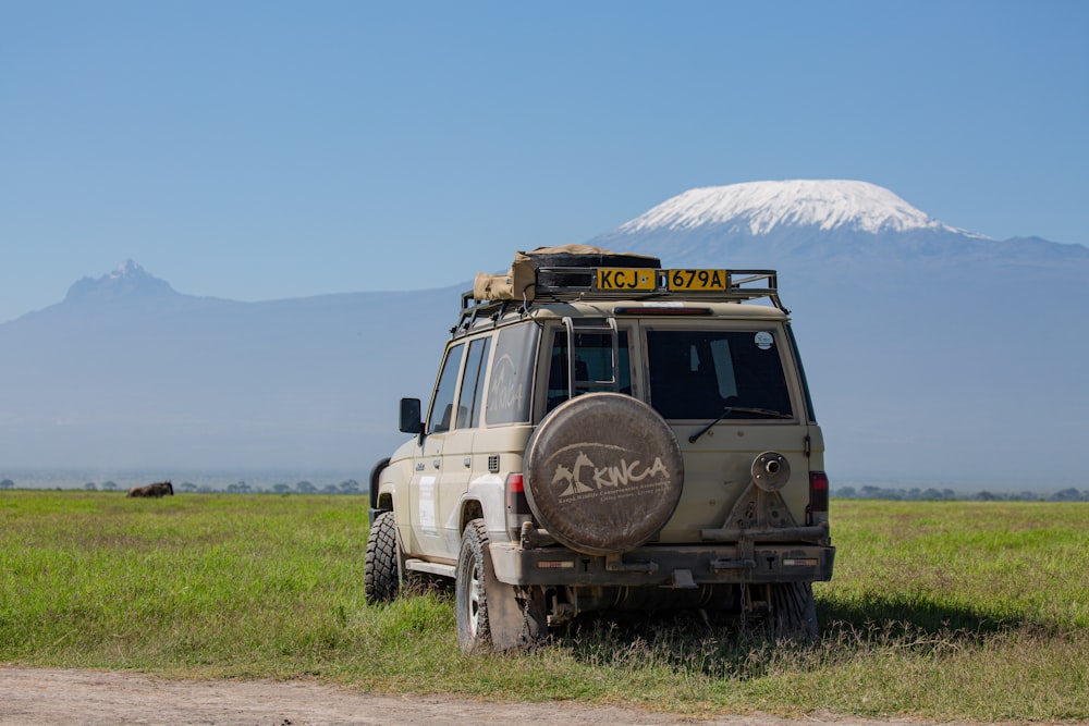 a jeep parked on a road with a mountain in the background