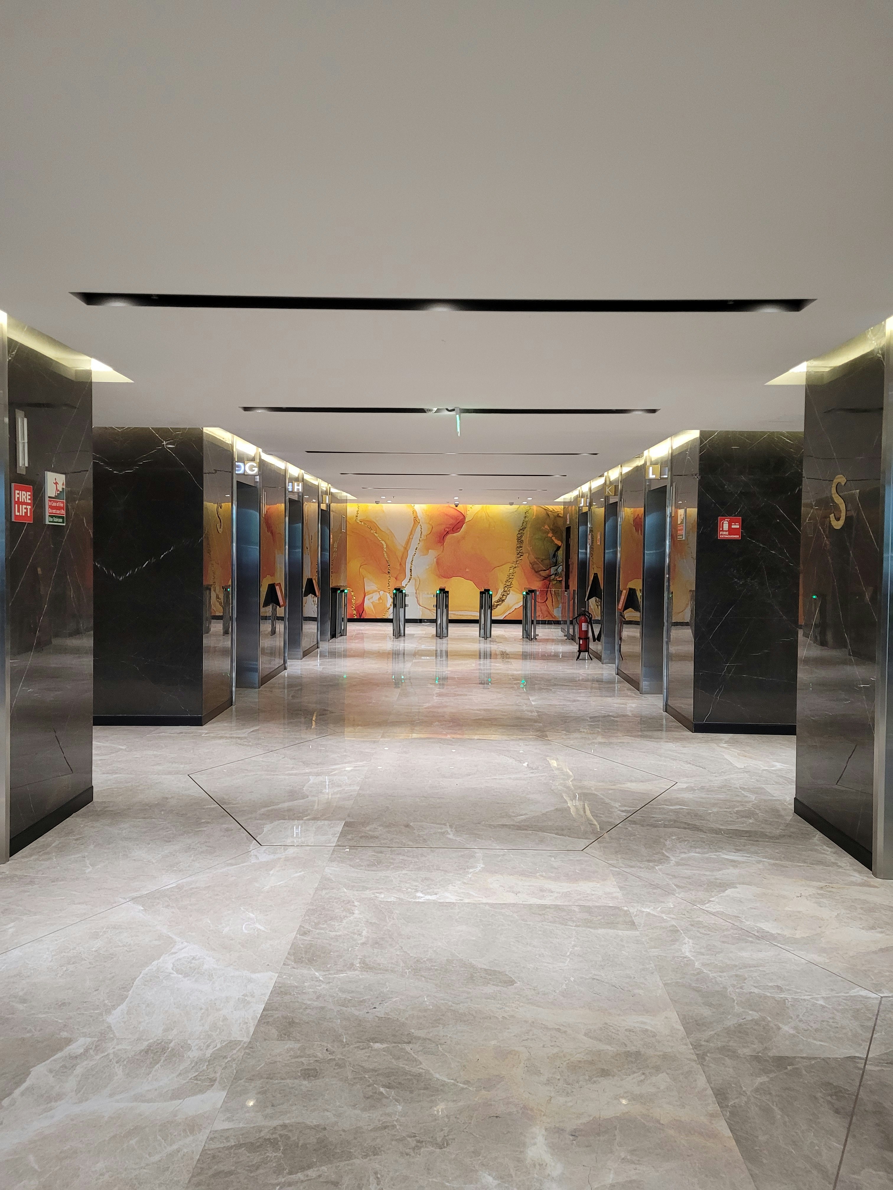 Modern office building lobby with polished marble floors, bright lighting, and clean glass entrance doors
