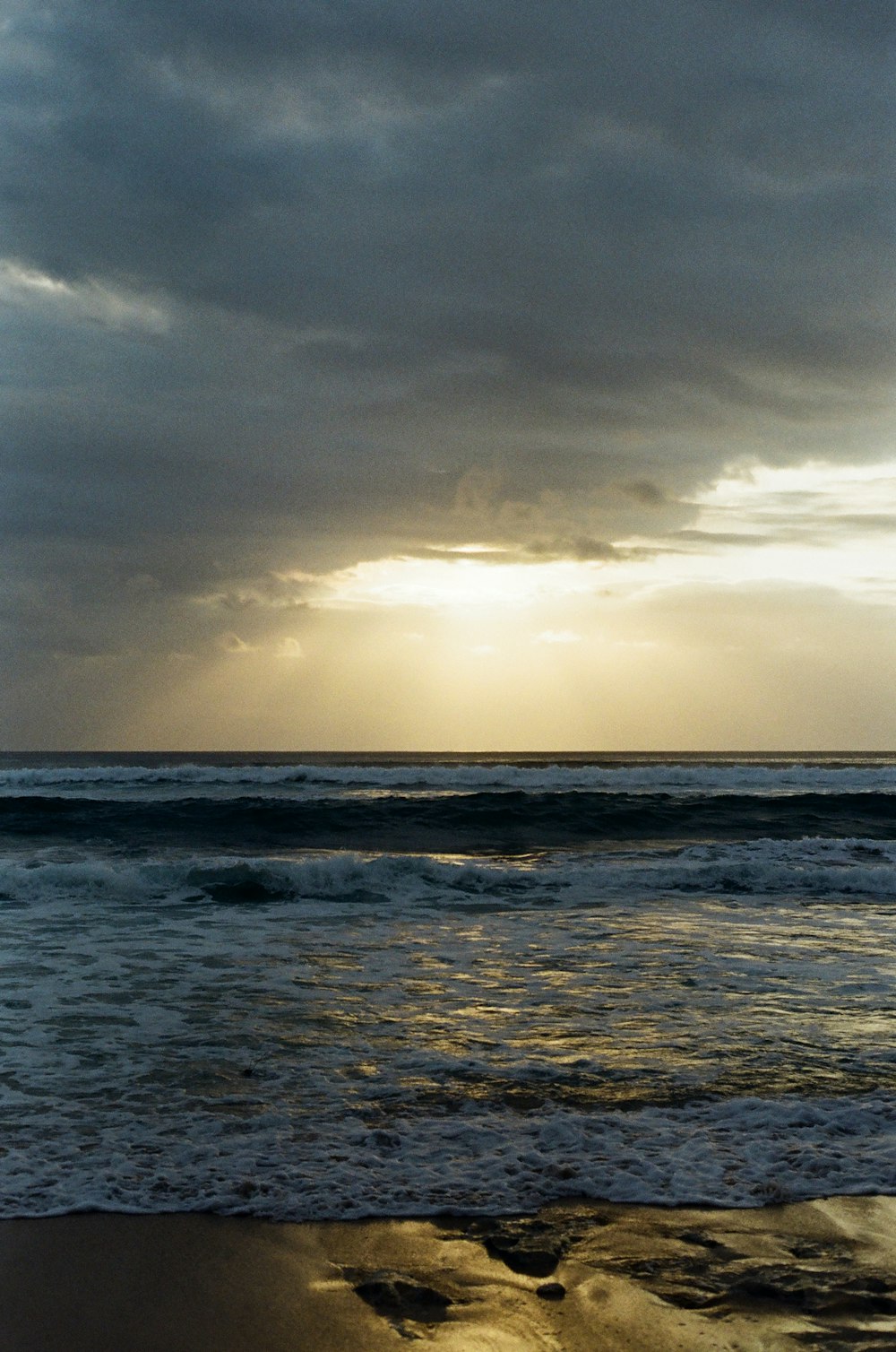 Une plage avec des vagues et un ciel nuageux