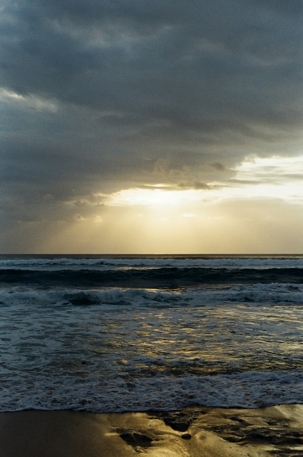 Una playa con olas y un cielo nublado