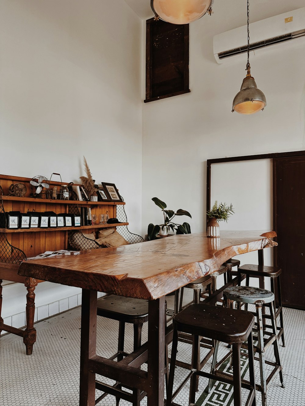 a dining table with chairs and a shelf with books on it