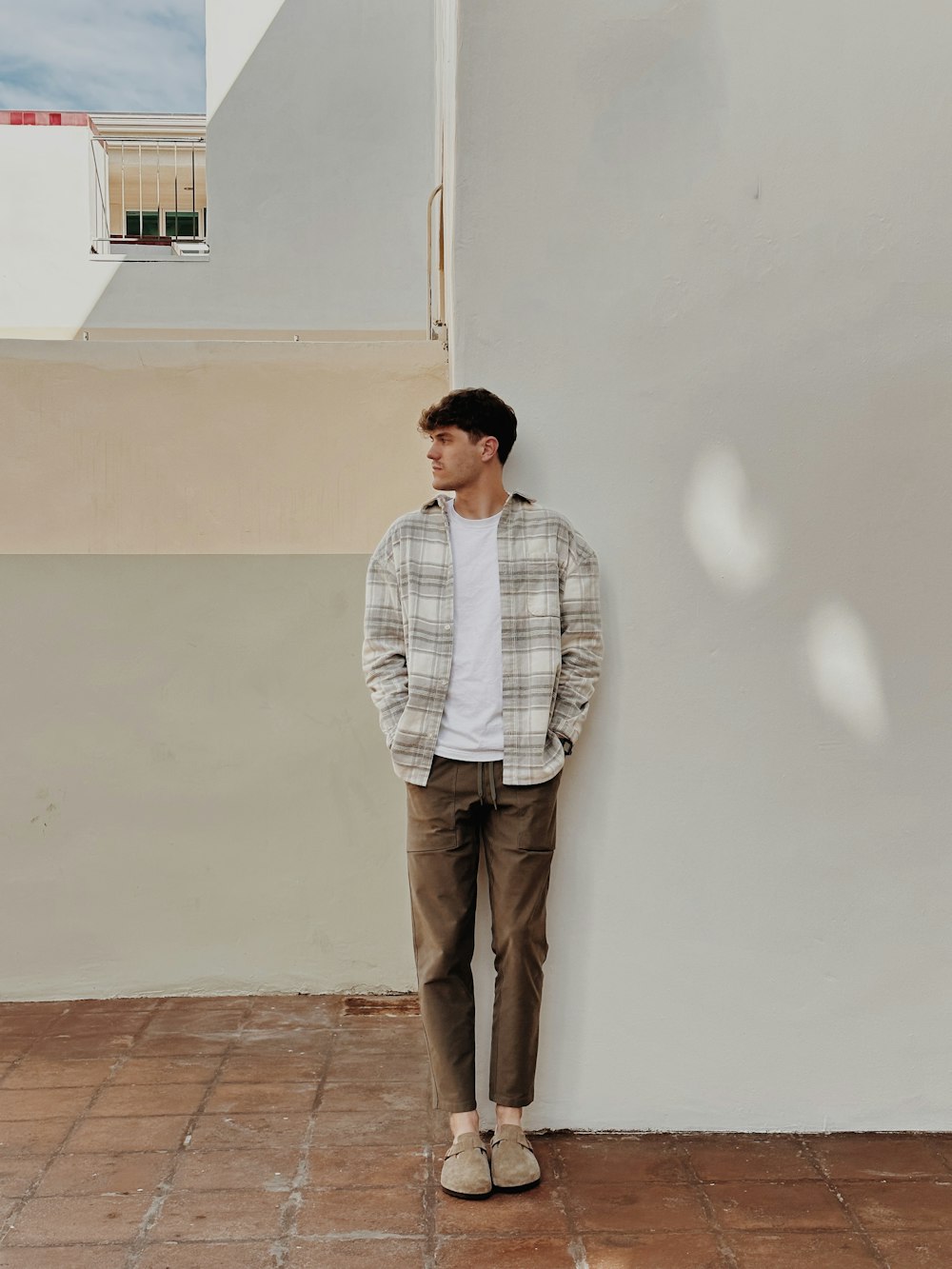Un uomo in piedi di fronte a un muro bianco