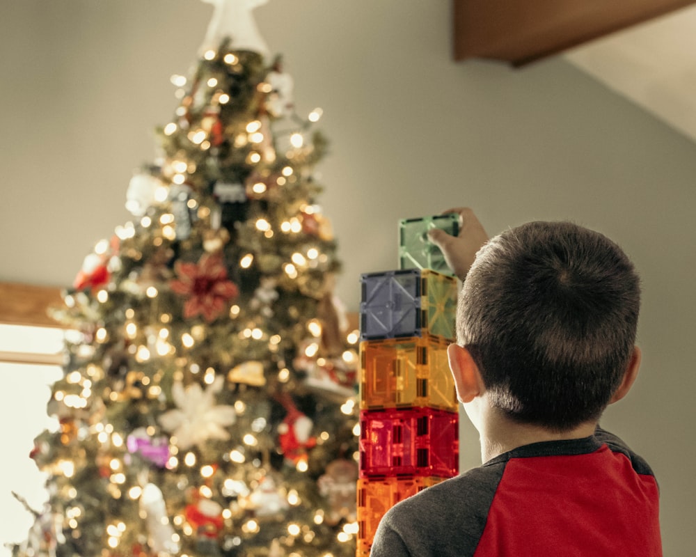 a boy looking at a decorated tree