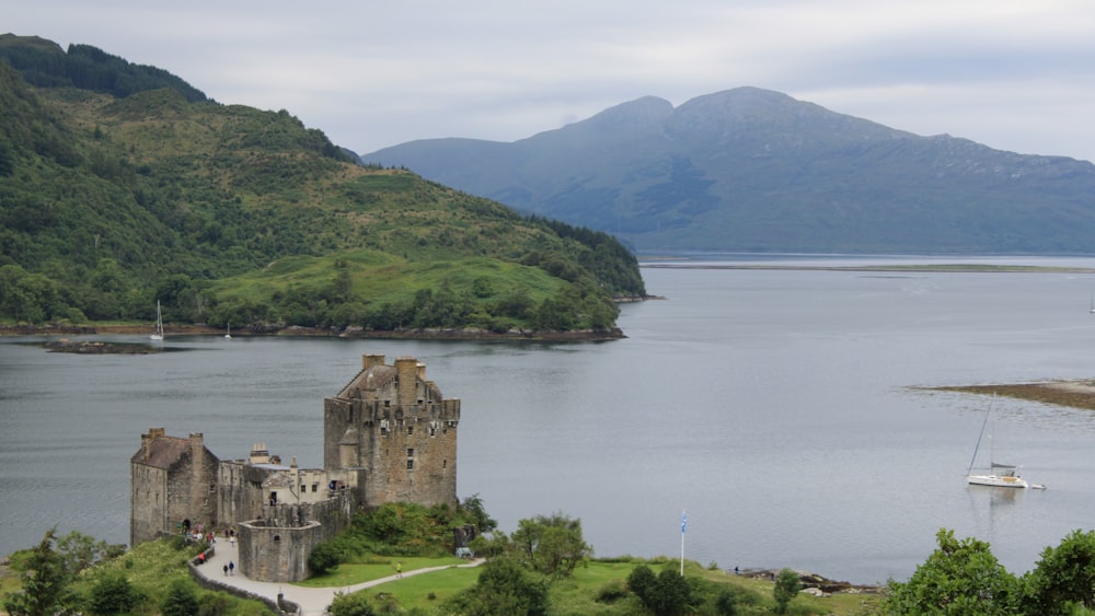 a castle on a hill by a lake