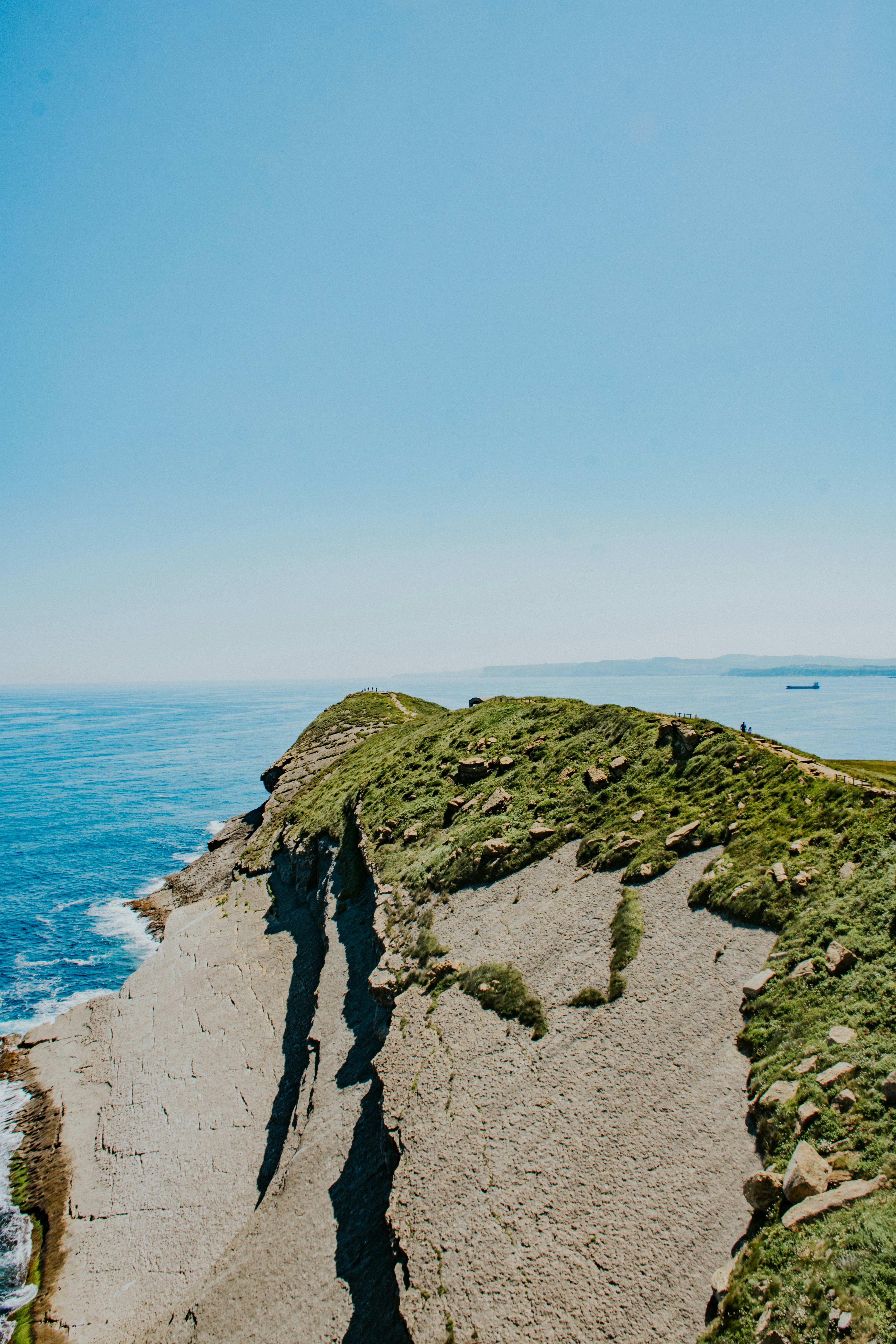 a rocky beach with a body of water in the background
