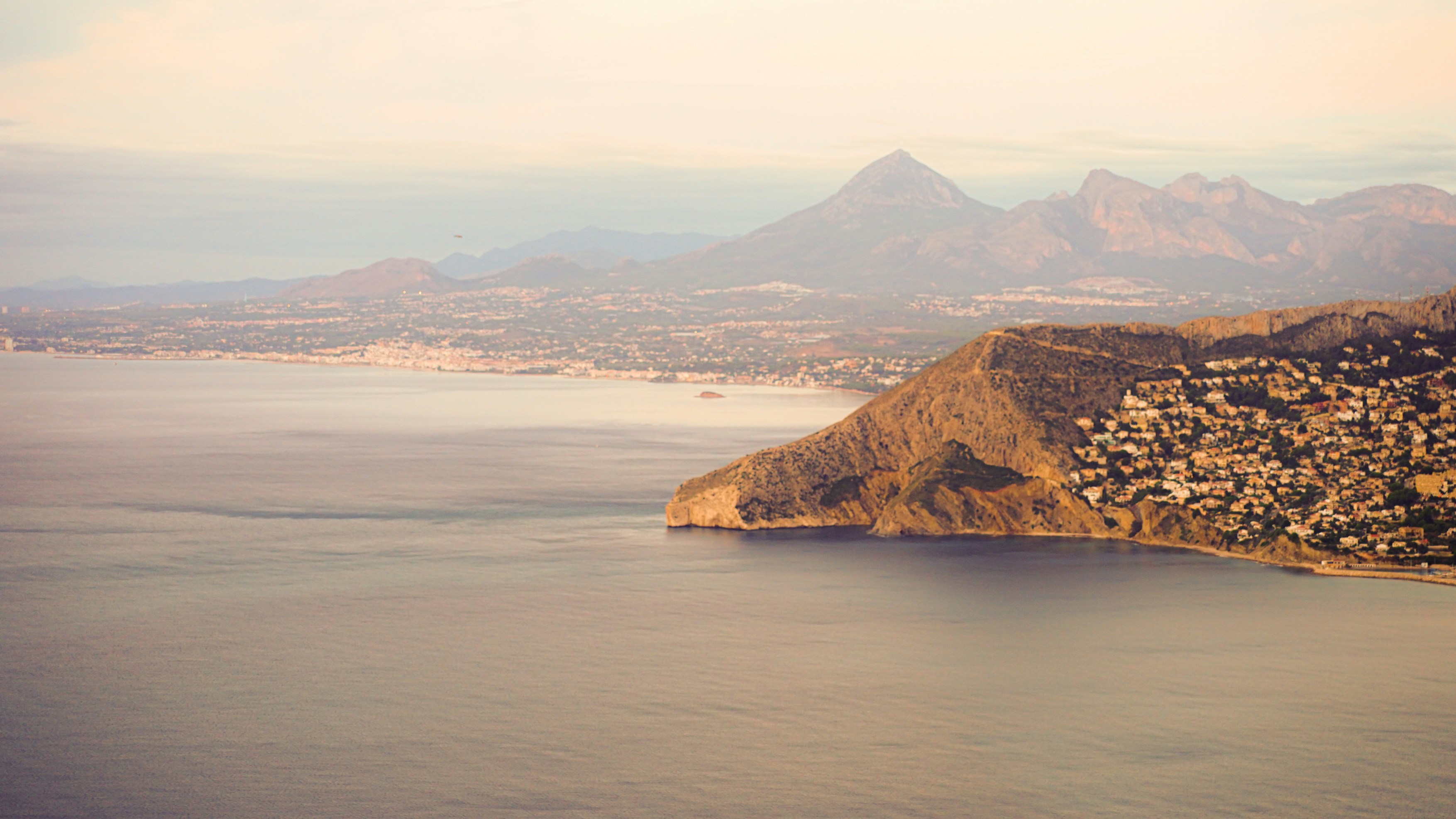 Beach · a body of water with a rocky shoreline and mountains in the background