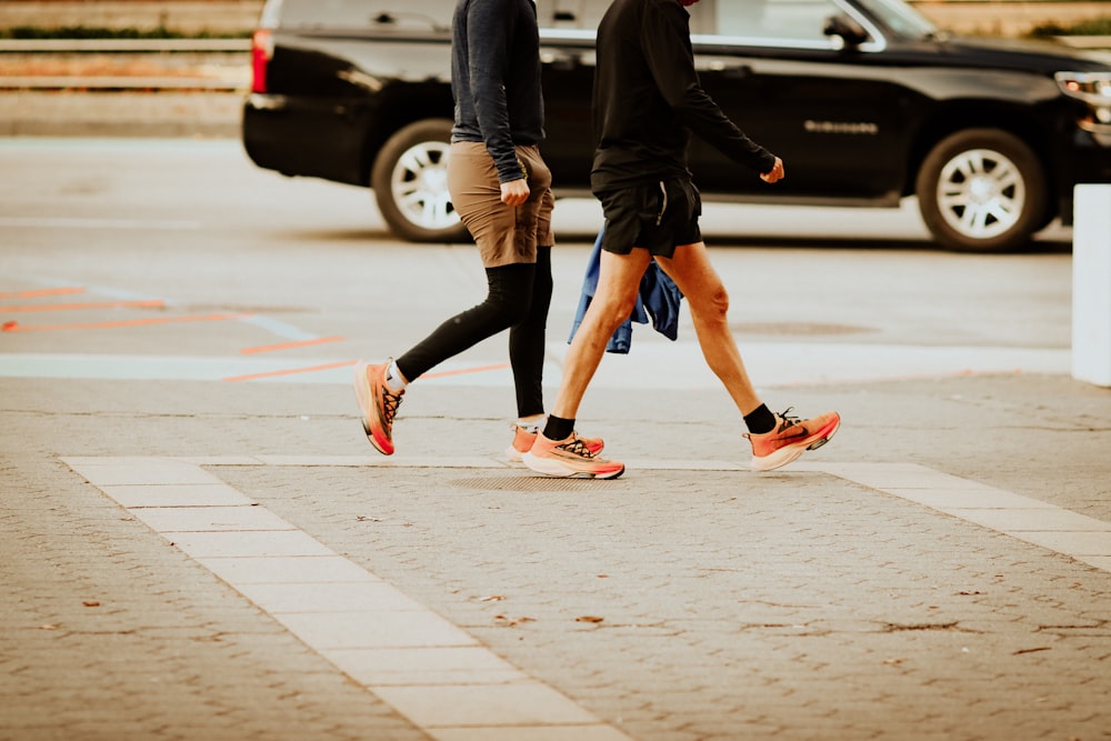 a pair of people running on a sidewalk