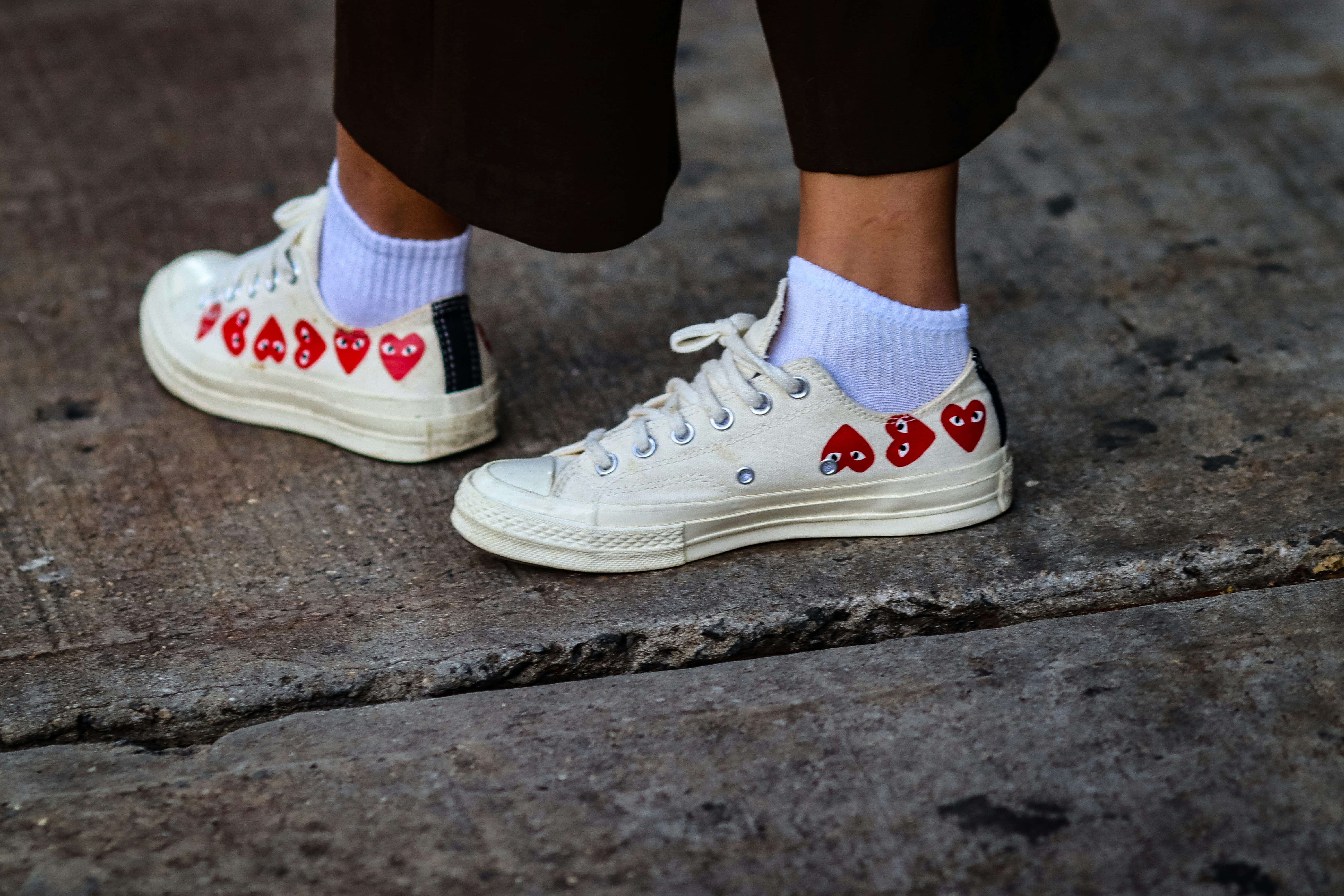 A pair of white sneakers photographed as a clean footwear detail