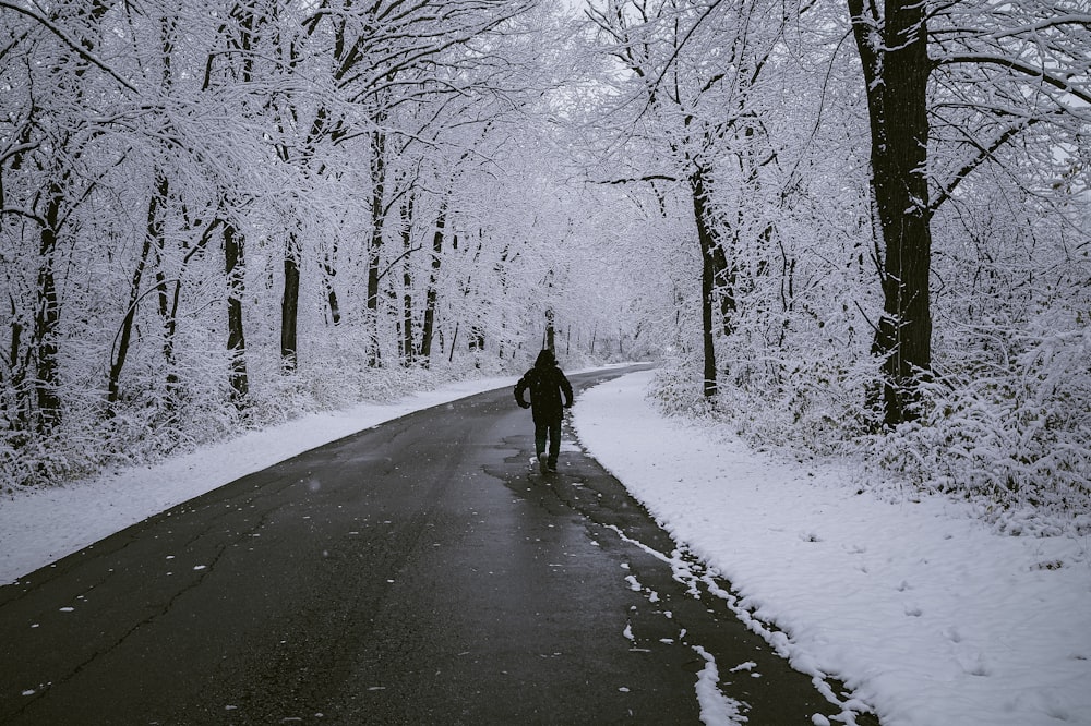 Una persona che cammina su una strada nella neve