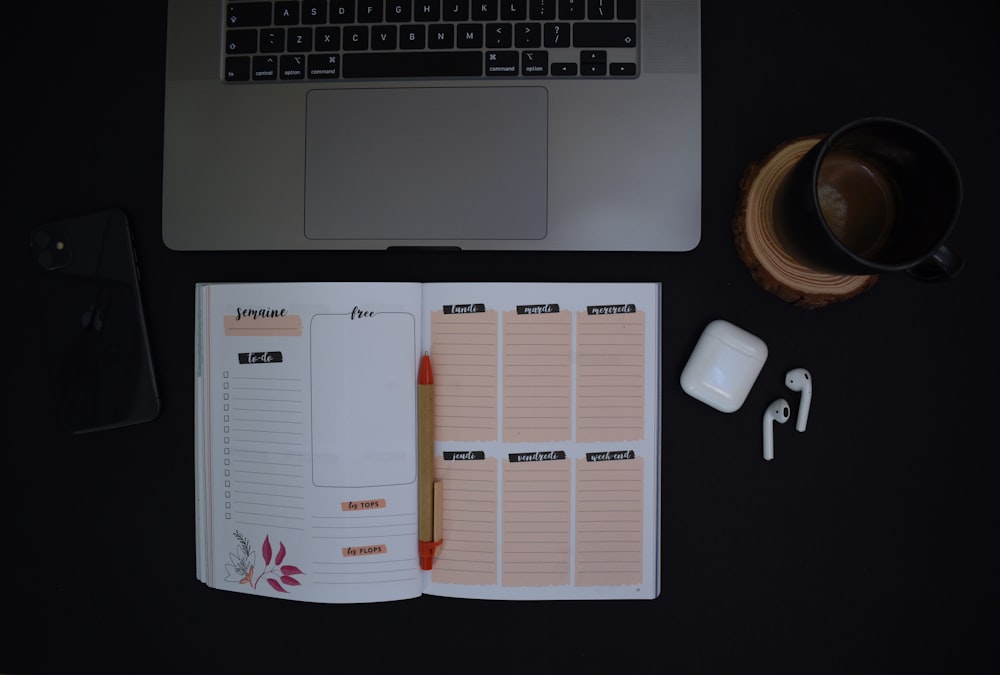 a notebook and a cup of coffee on a desk