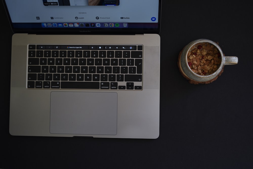 a laptop with a bowl of food