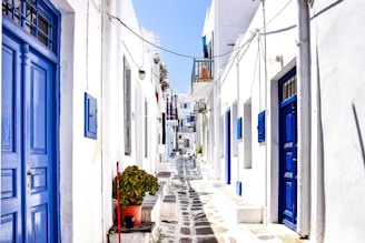 a narrow street between white buildings