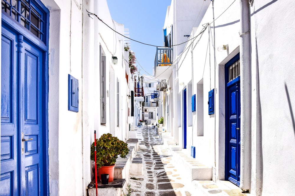 a narrow street between white buildings