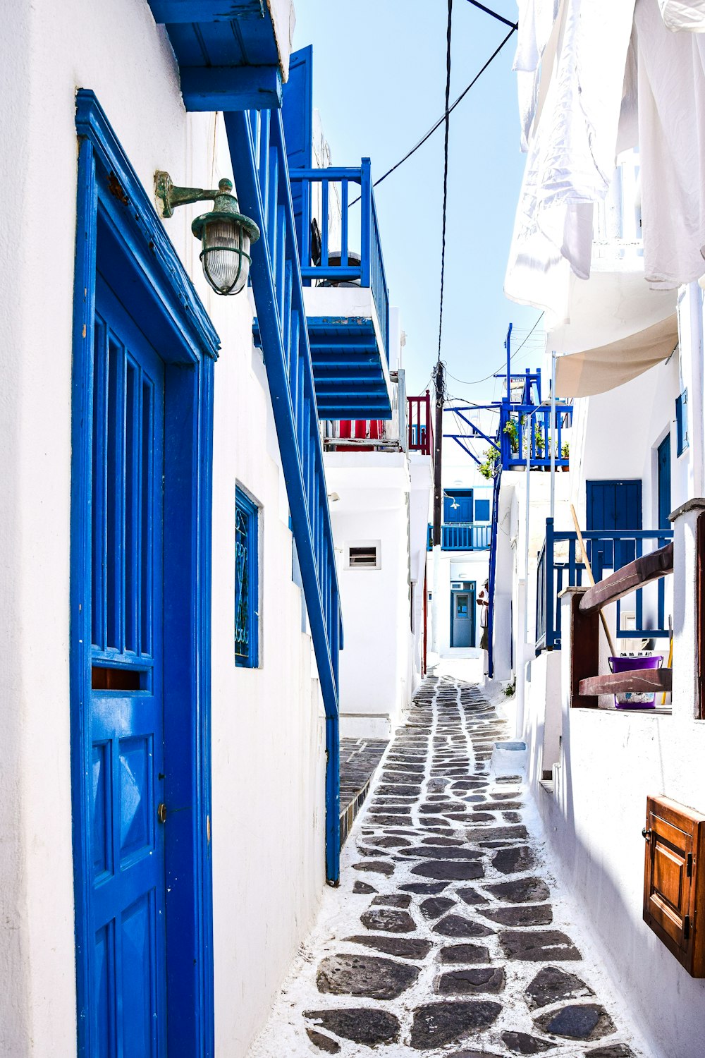 a narrow street with blue and white buildings