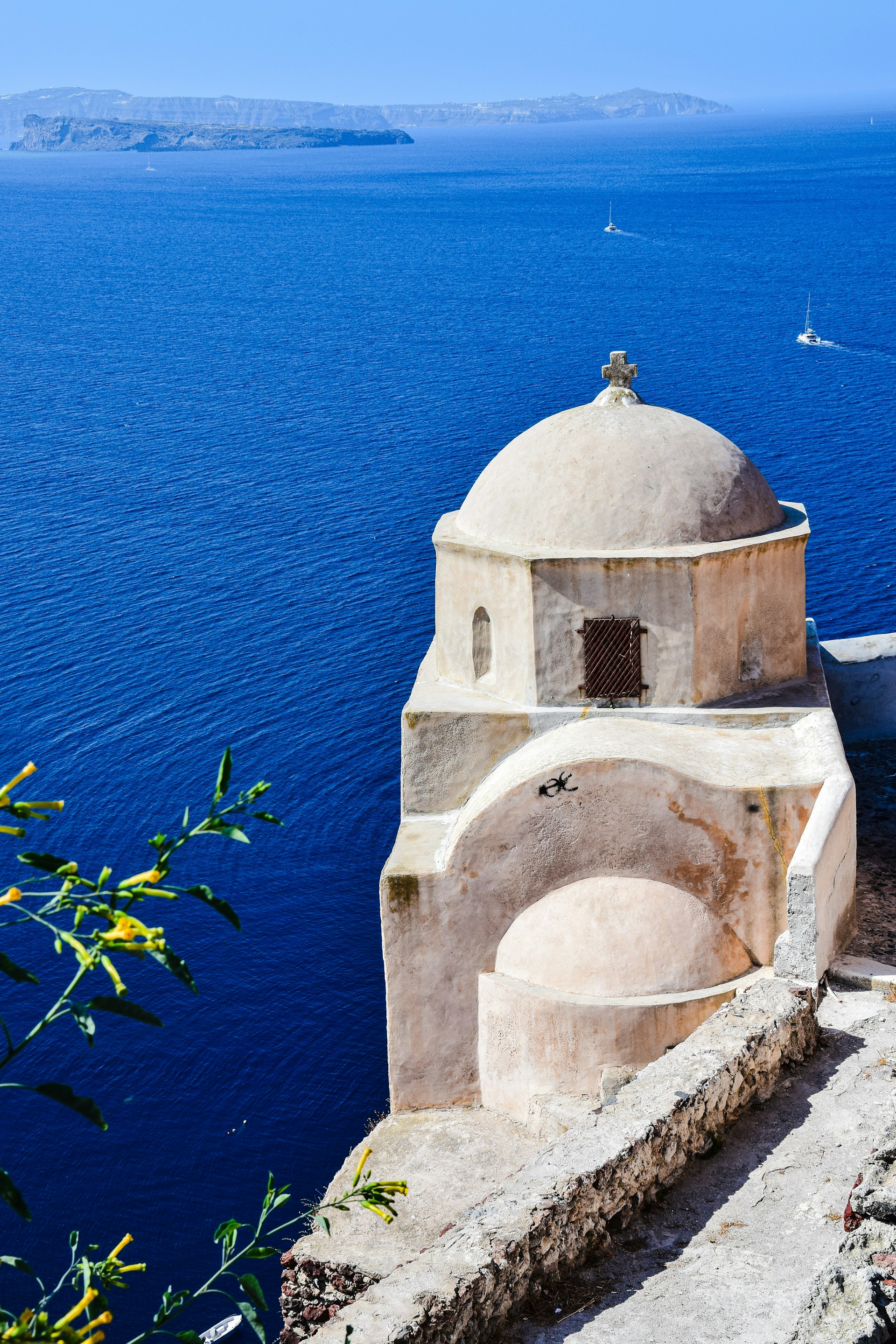 a white building on a cliff above water