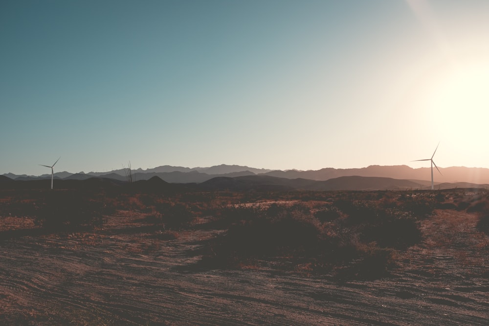 a desert landscape with wind turbines