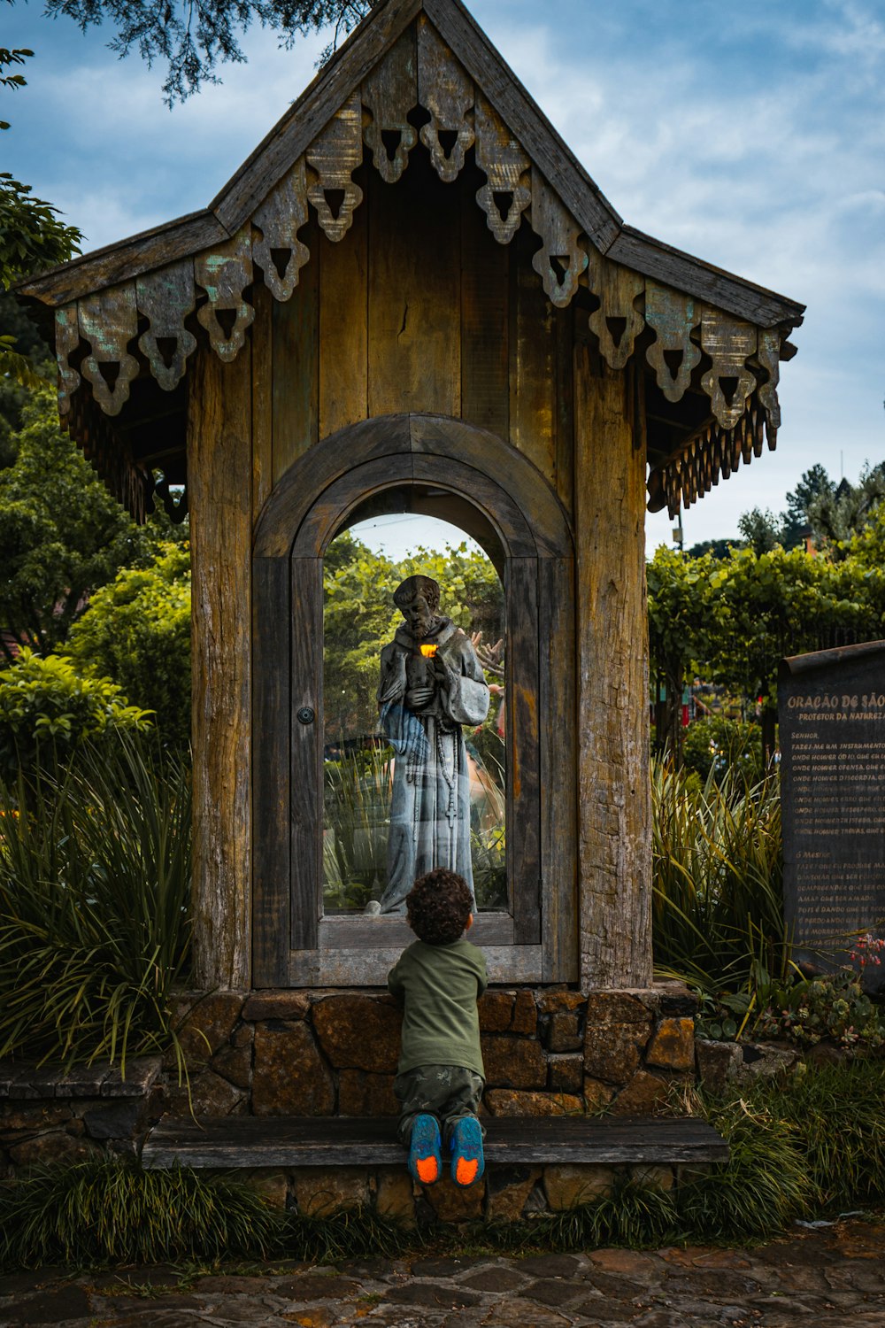 a boy standing in front of a statue of a person