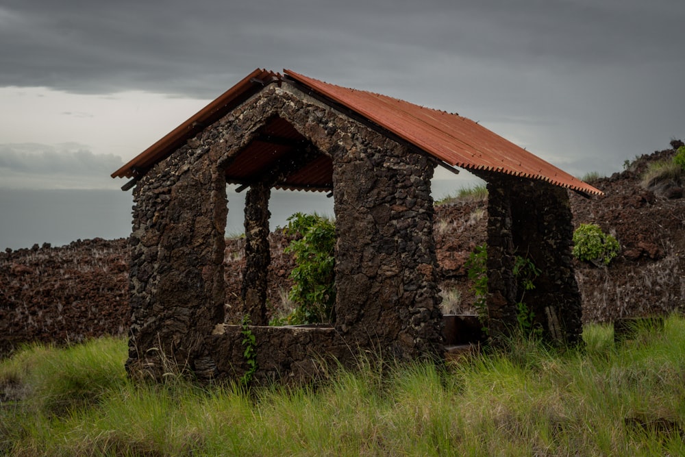 a stone building with a grass field