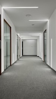 A hallway with newly painted soft gray walls and bright white ceiling, highlighting clean lines.
