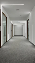 A sleek, modern apartment hallway freshly renovated with clean lines and warm lighting.