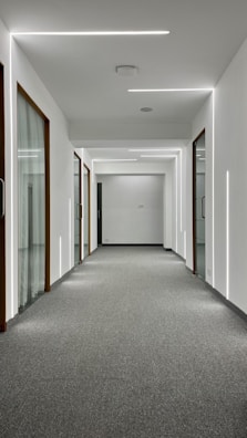 A bright hallway with freshly vacuumed carpet and clean walls.