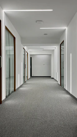 A sleek, modern apartment hallway freshly renovated with clean lines and warm lighting.