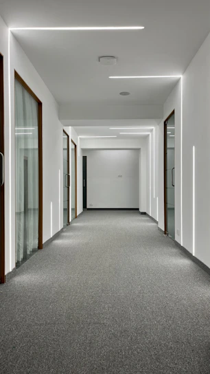 A sleek, modern apartment hallway freshly renovated with charcoal gray walls, gold accents, and bright lighting.