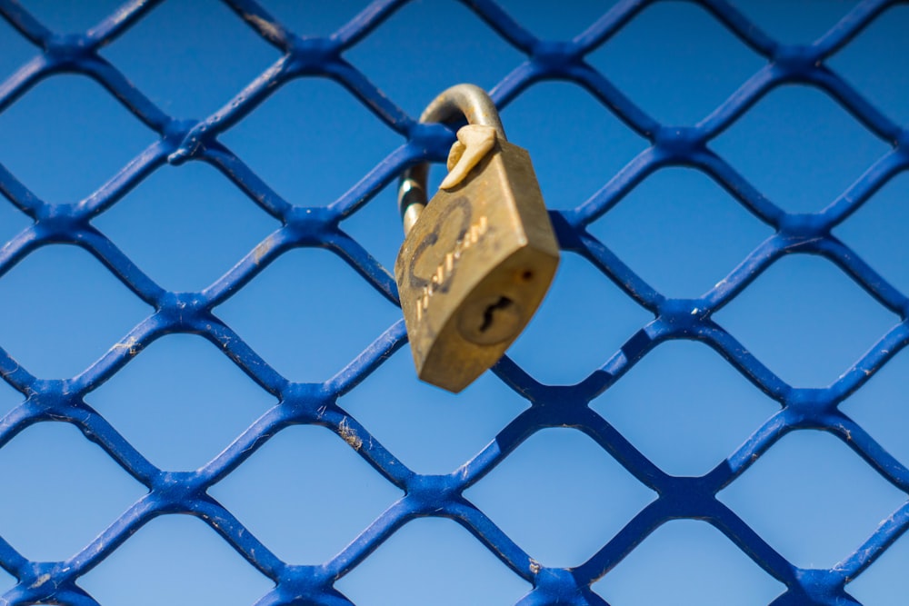 a yellow metal object on a chain link fence