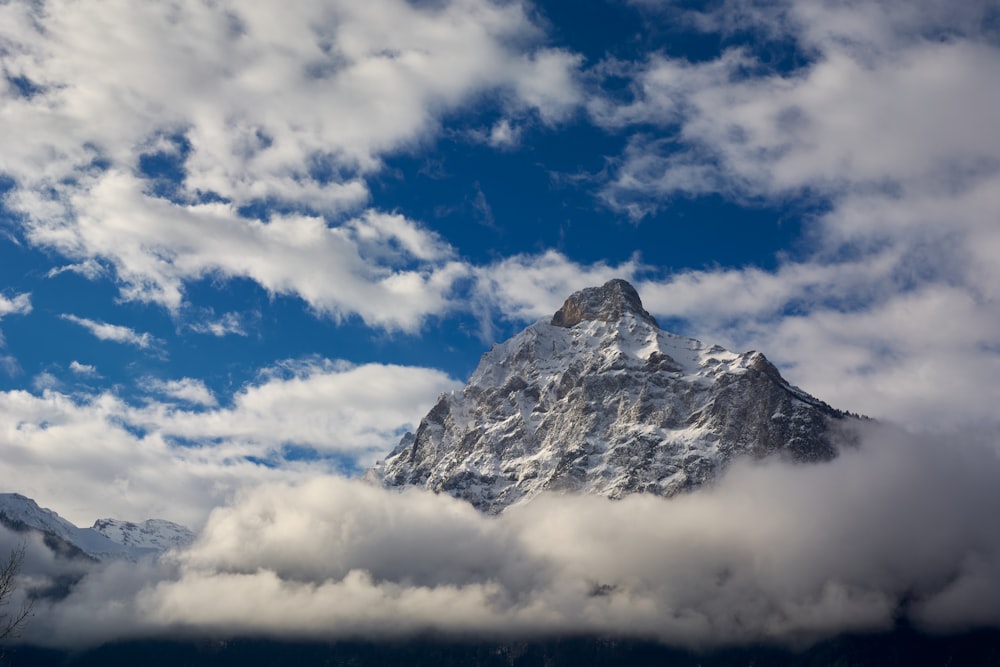 a mountain with clouds below