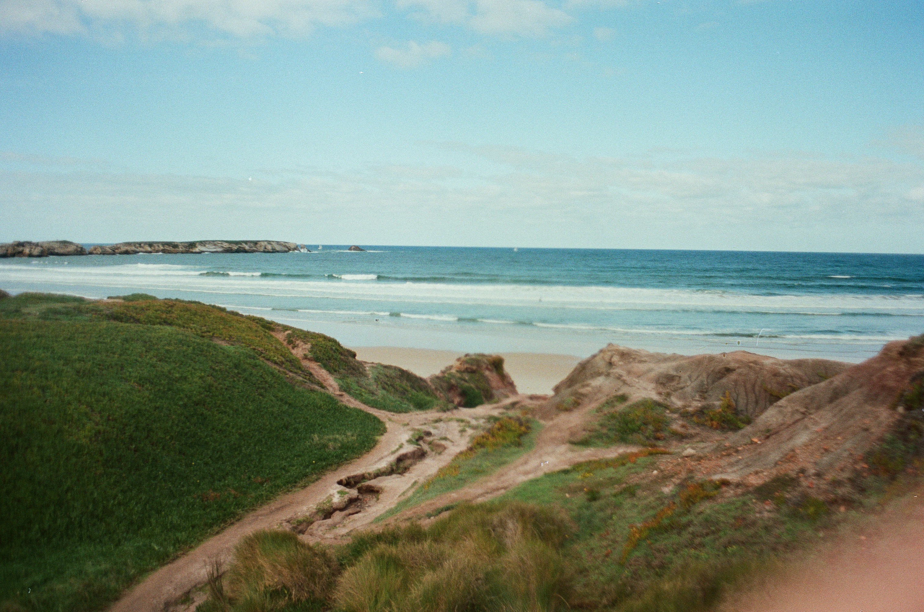 a beach with a path and grass