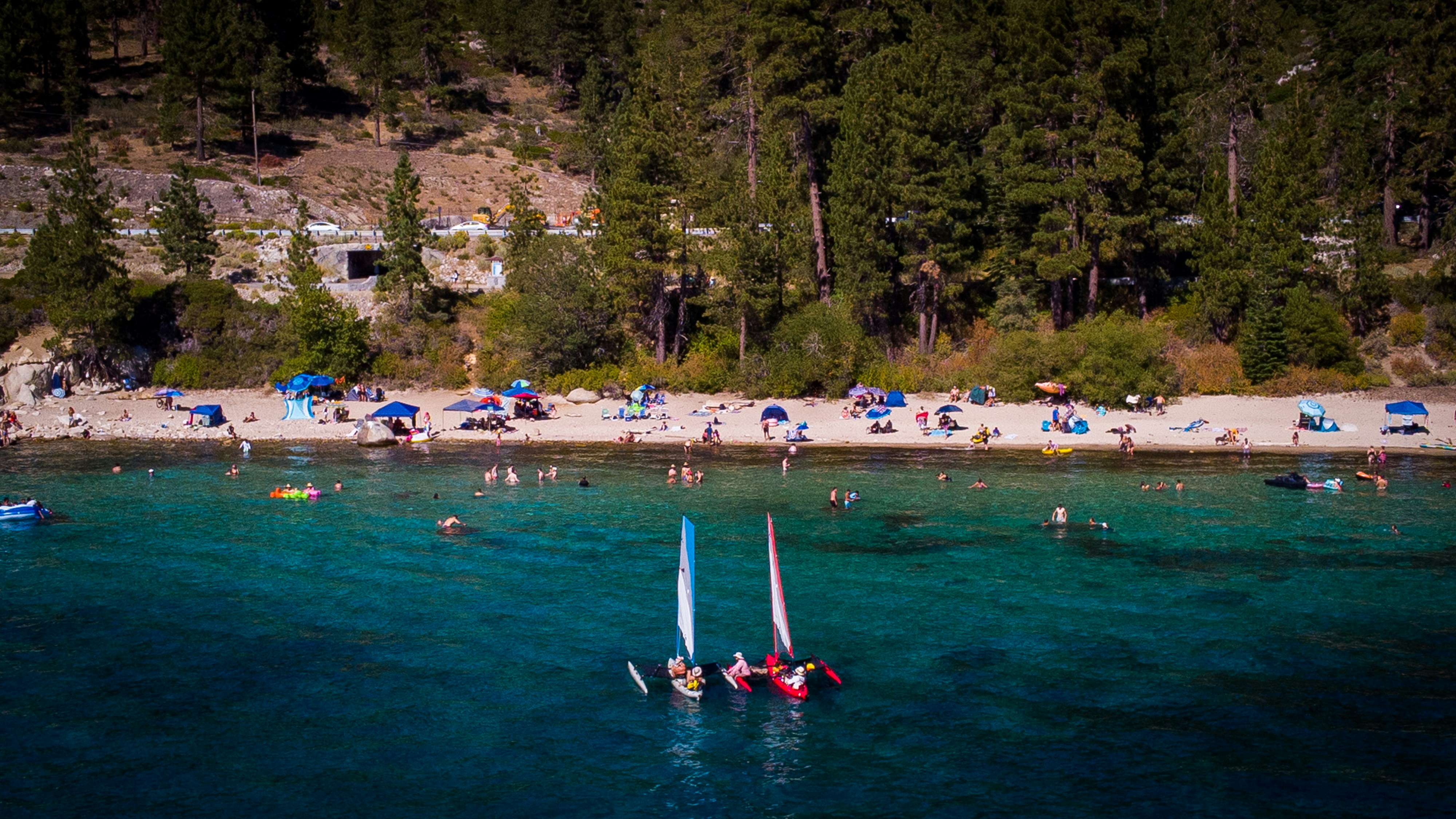a beach with people and boats