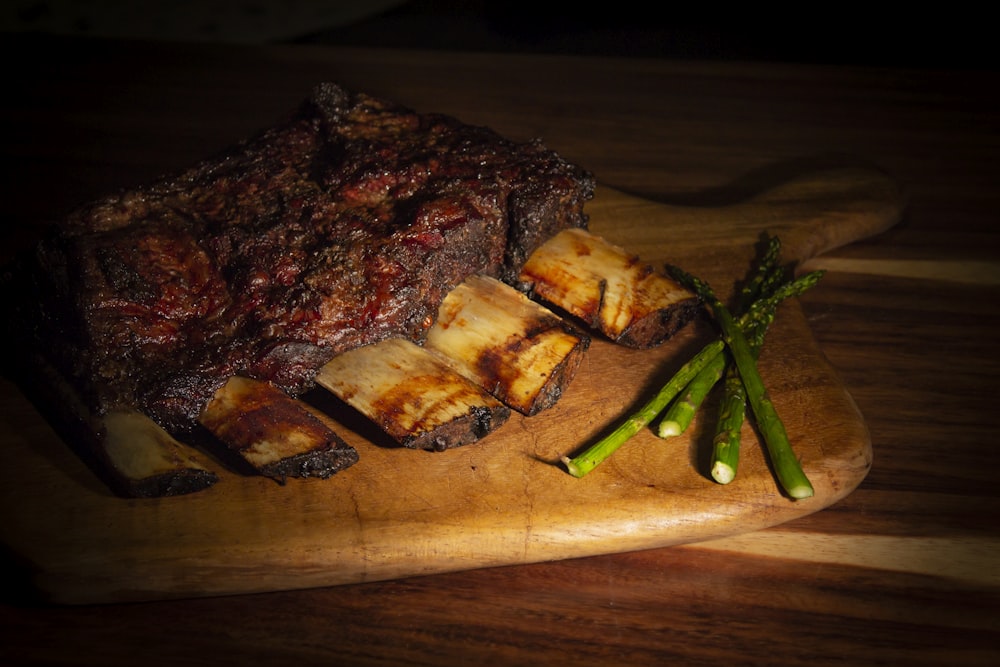 a piece of meat with a green stem on a wooden surface