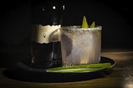 Close-up of a gourmet cocktail being served on a silver tray at an exclusive soirée.