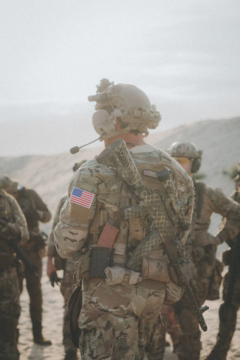 A Veteran in uniform with an American flag patch standing with fellow service members