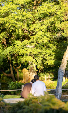 A serene portrait of a couple sharing a quiet moment in a sunlit park